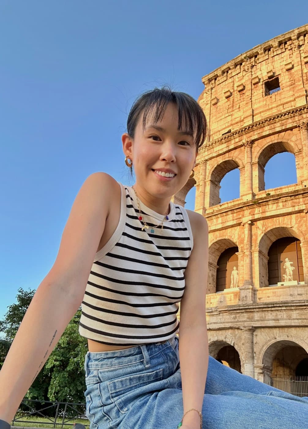 Michelle in front of the Colosseum in Rome at golden hour