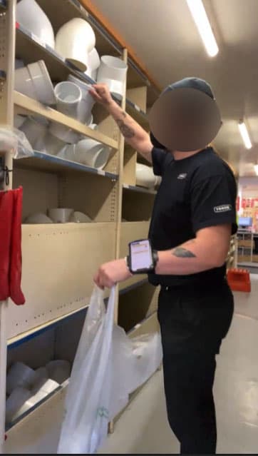 Picking goods from the warehouse shelving using the wristband-mounted phone.