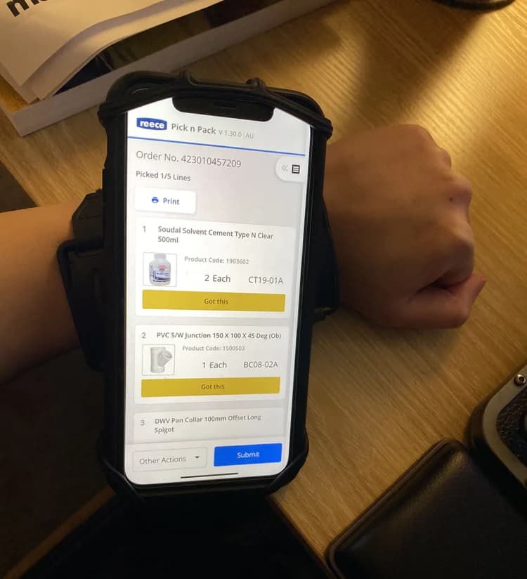 A staff member wearing the phone on a wristband while picking stock.